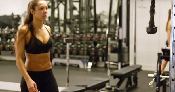 Sportos nő képzés tricepsz izmok húzza kábel gép-ban tornaterem - Felvétel, videó