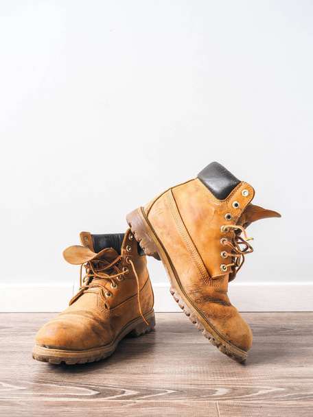 Pair of old yellow working boots - 写真・画像