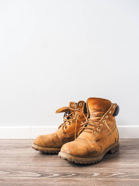 Pair of old yellow working boots - 写真・画像