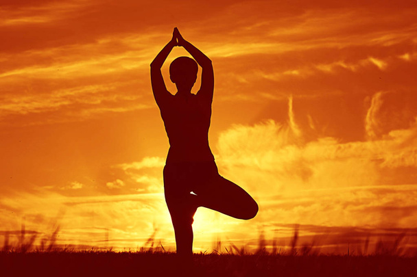nő, jóga, napnyugtakor ég ellen - Fotó, kép