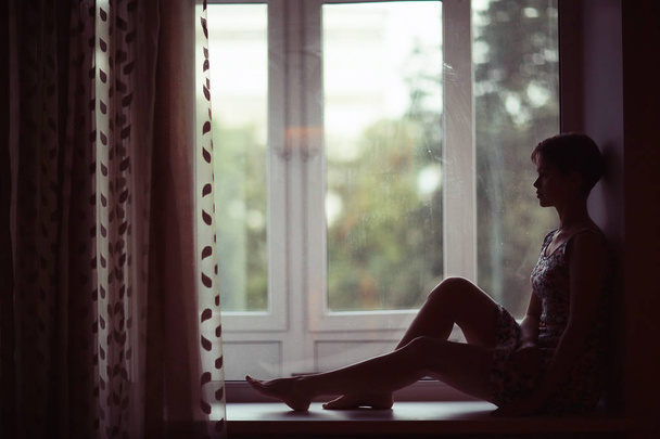 woman sitting on windowsill  - Valokuva, kuva