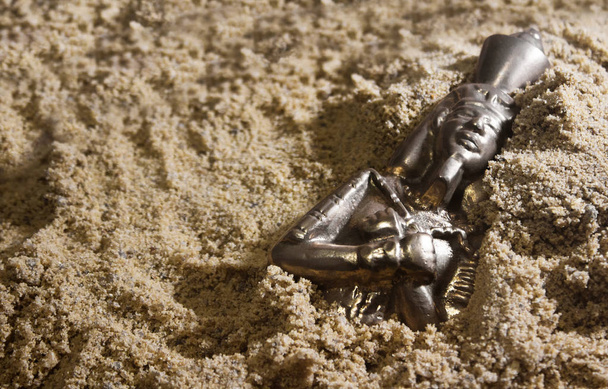 Statuetta di metallo faraone che posa nella sabbia
. - Foto, immagini