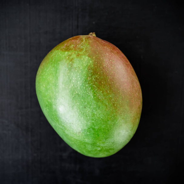 Top view of fresh mango on black background - Foto, imagen