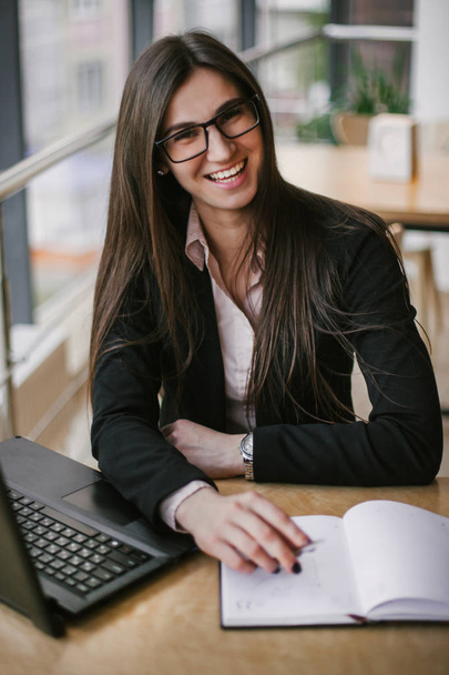 Business woman sitting in the office with a beautiful smile - Foto, Imagen