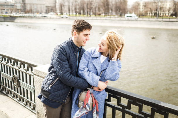 Young Guy and girl embrace on the bridge background - Foto, imagen