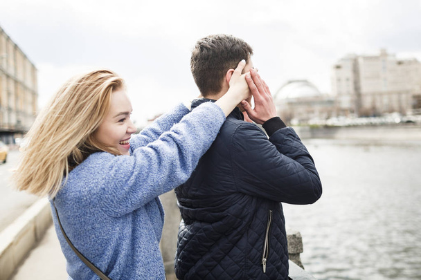Girl closes her boyfriend's eyes on date - Foto, imagen