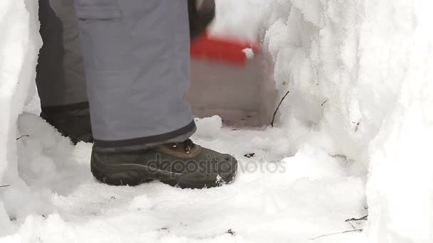 Man met schop reinigt de sneeuw van de weg na zware sneeuwval en lawines - Video