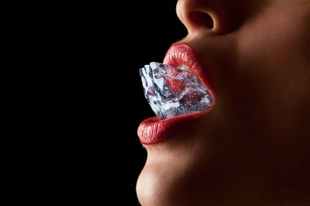 Ice cube in woman's mouth. - 写真・画像