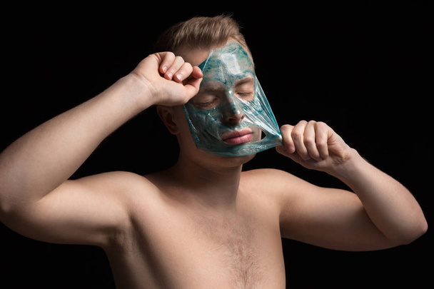 man with cleaning clay facial mask - Zdjęcie, obraz