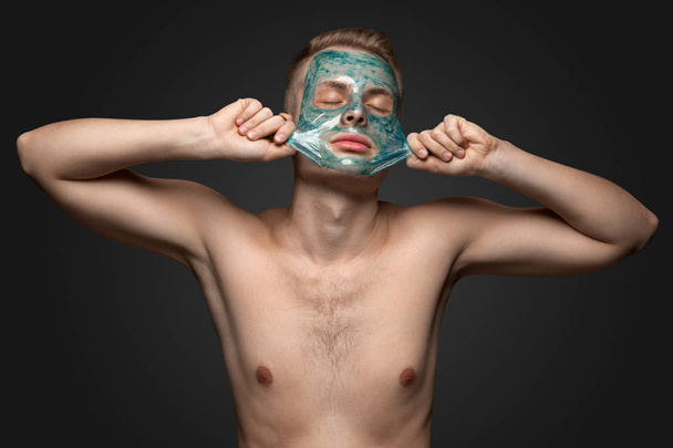 man with cleaning clay facial mask - Fotoğraf, Görsel