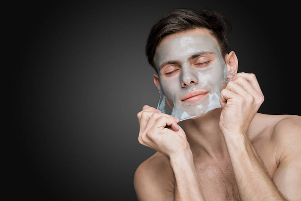 man with cleaning clay facial mask - Fotó, kép