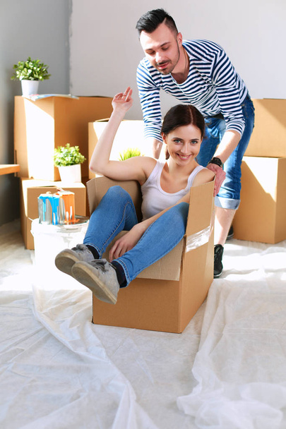 Happy young couple unpacking or packing boxes and moving into a new home - Fotografie, Obrázek
