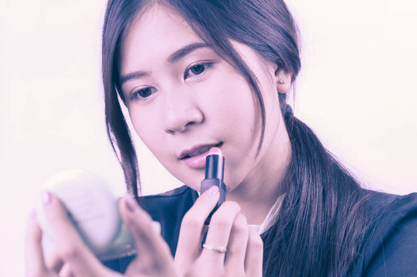 Ázsiai nő smink alkalmazása, segítségével a rúzs, a szépség fogalma  - Fotó, kép
