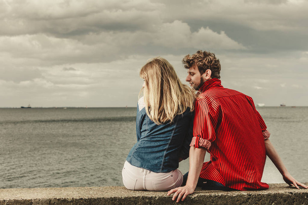 Couple sitting hugged on sea shore - Zdjęcie, obraz