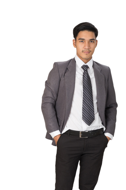 Бизнесмен в сером костюме стоит и позирует над белым Bac
 - Фото, изображение