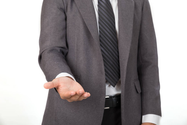 Geschäftsmann in lässigem grauen Anzug, der Hand anlegt, fragt oder anbietet - Foto, Bild