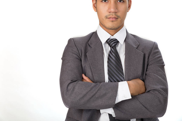 Homme d'affaires réfléchi pose à la caméra avec les bras croisés sur blanc
 - Photo, image
