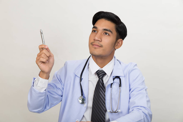 gondolkodó fiatal férfi orvos gondolni a kezelés és a pointi - Fotó, kép