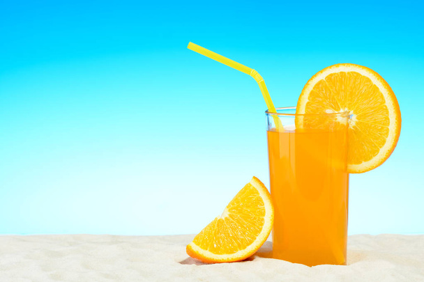 Szklanka soku pomarańczowego na plaży - Zdjęcie, obraz