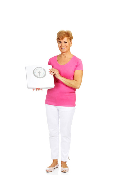Smiling old woman holding weight scale - Photo, Image