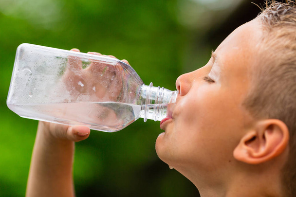 Young boy drinking water from bottle - Fotoğraf, Görsel