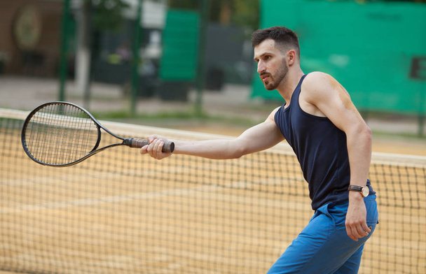 Happy young man playing on tennis clay court. - Fotó, kép