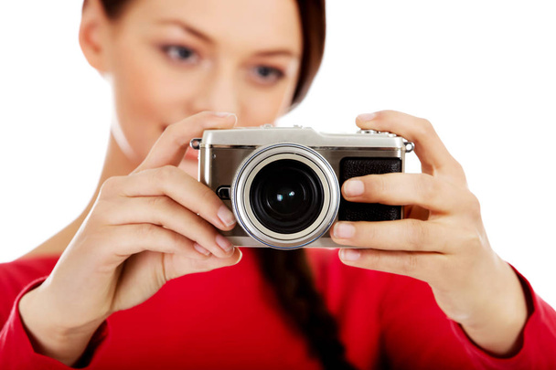 Mujer bonita tomando una foto usando la clásica cámara slr
 - Foto, imagen