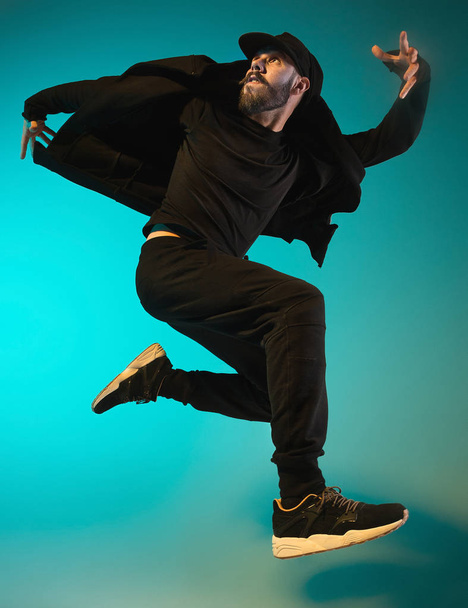 The silhouette of one hip hop male break dancer dancing on colorful background - Foto, Imagen