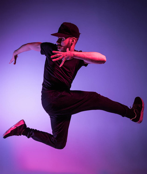 The silhouette of one hip hop male break dancer dancing on colorful background - Foto, Bild
