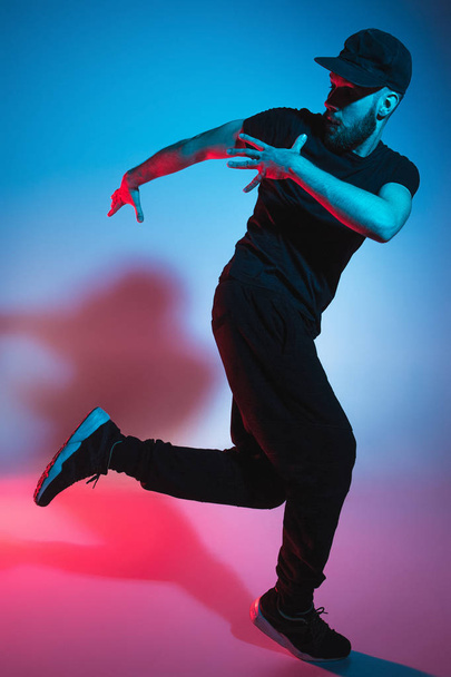 The silhouette of one hip hop male break dancer dancing on colorful background - Фото, изображение