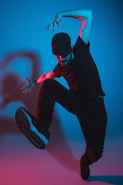 The silhouette of one hip hop male break dancer dancing on colorful background - Foto, imagen