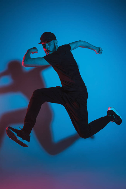 The silhouette of one hip hop male break dancer dancing on colorful background - Valokuva, kuva