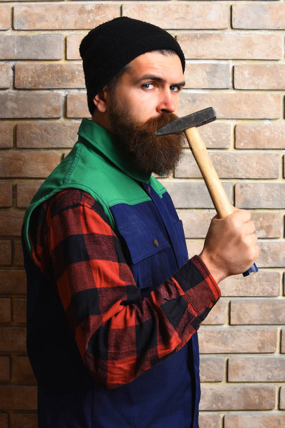 bearded builder man holding hammer serious face - Foto, imagen