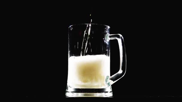 Pivo nalévá do sklenice na černém pozadí. Zpomalený pohyb - Záběry, video