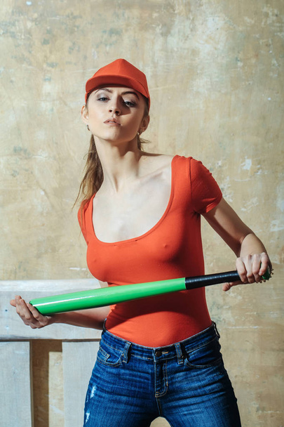 Pretty girl in red cap with green bat - 写真・画像