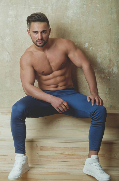 Handsome athletic man with sexy torso sitting - Fotografie, Obrázek
