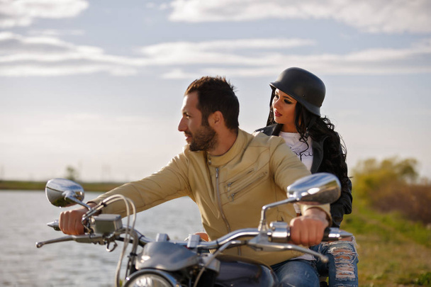 Beautiful young couple with a classic motorcycle - Zdjęcie, obraz