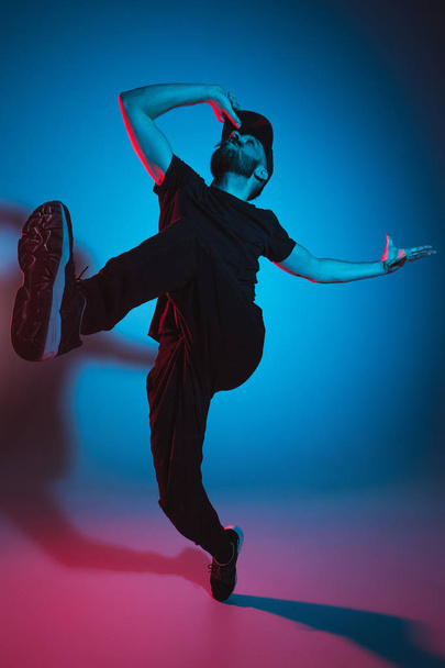The silhouette of one hip hop male break dancer dancing on colorful background - Foto, imagen