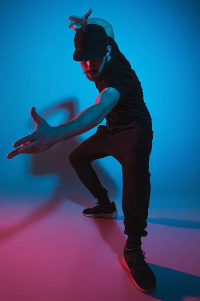 The silhouette of one hip hop male break dancer dancing on colorful background - 写真・画像
