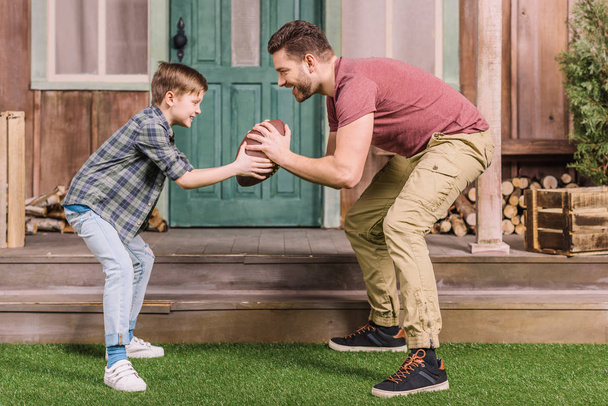 apa és fia játszik labda a kertben - Fotó, kép