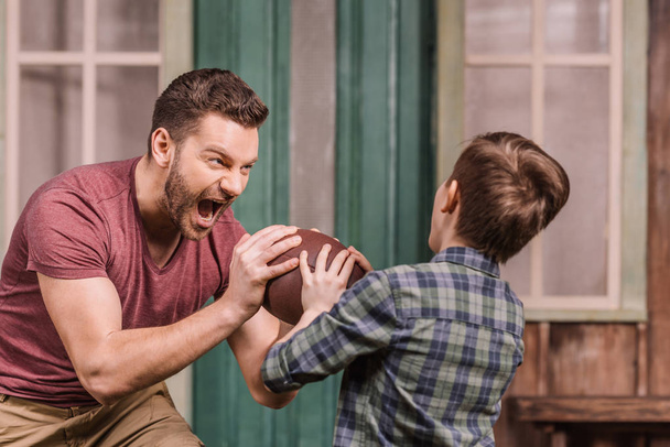 pai com filho brincando com bola no quintal
 - Foto, Imagem