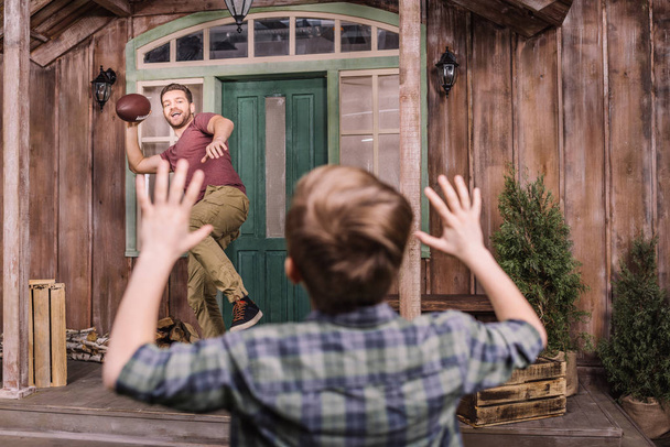 裏庭でボールで遊ぶ息子と父 - 写真・画像