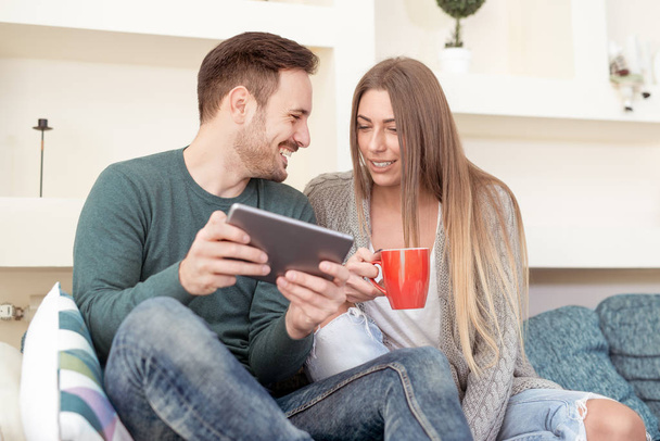 χαρούμενο ζευγάρι χρησιμοποιώντας ψηφιακή δισκίο στο σπίτι  - Φωτογραφία, εικόνα