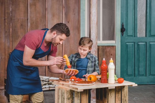 Father and son cooking hot dog  - 写真・画像