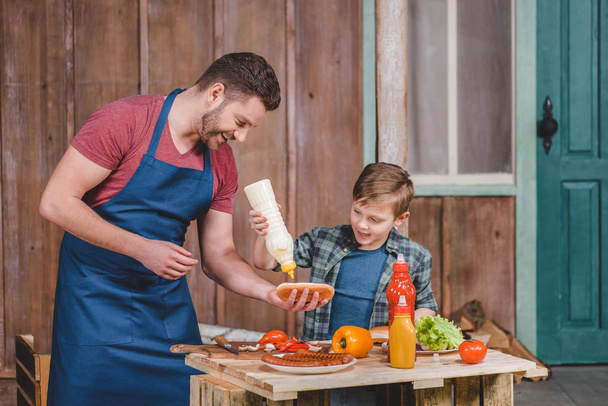 Father and son cooking hot dog  - Foto, Imagem