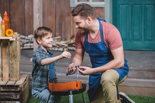 apa és fia grill előkészítése - Fotó, kép