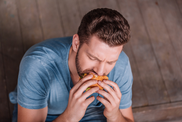 Hombre comiendo hamburguesa
 - Foto, Imagen