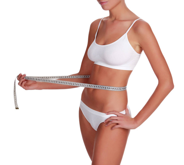Mujer mide su cintura, aislada sobre fondo blanco
 - Foto, Imagen