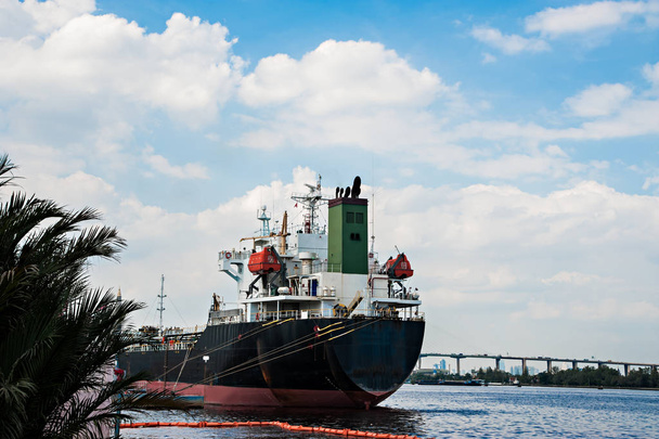 Koncepcja logistyczna, czarny statek zaparkowany w rzece - Zdjęcie, obraz