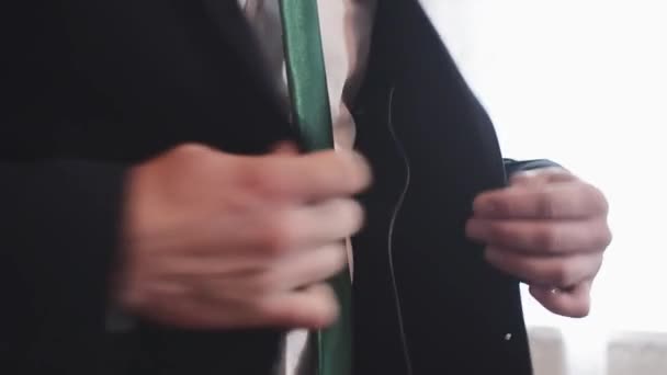 man in white shirt and green tie buttoning the suit jacket, closeup - Video, Çekim